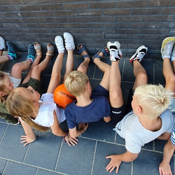 Kinderen met voeten tegen de muur